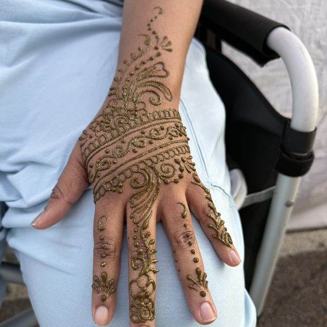 Fine dotwork and vine henna pattern on the hand