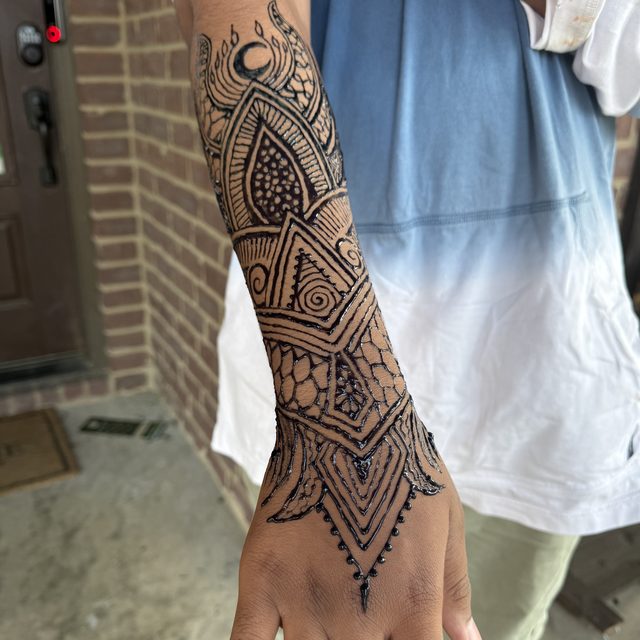 Geometric triangle henna pattern on the forearm
