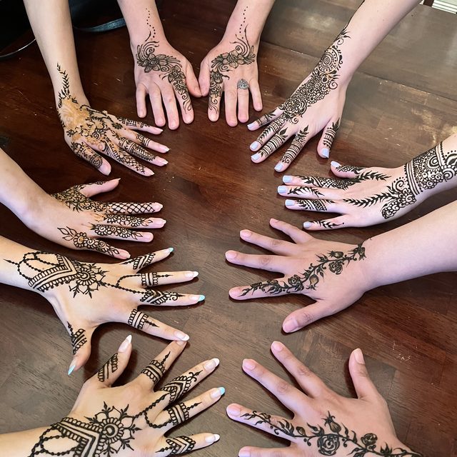 Group of henna-decorated hands arranged in a circle