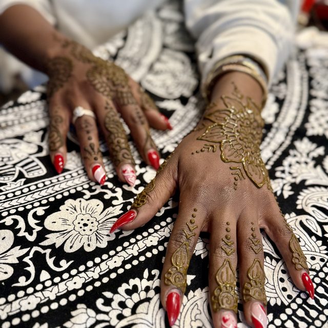 Detailed henna vine pattern flowing across the hand and fingers
