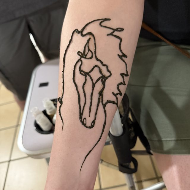 Horse outline henna design on the forearm