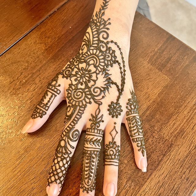 Intricate henna design covering the hand and fingers