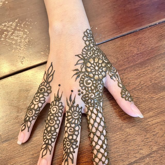 Lace-style henna pattern on the hand and fingers