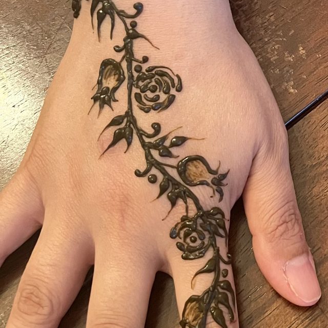 Rose and vine henna design on the hand