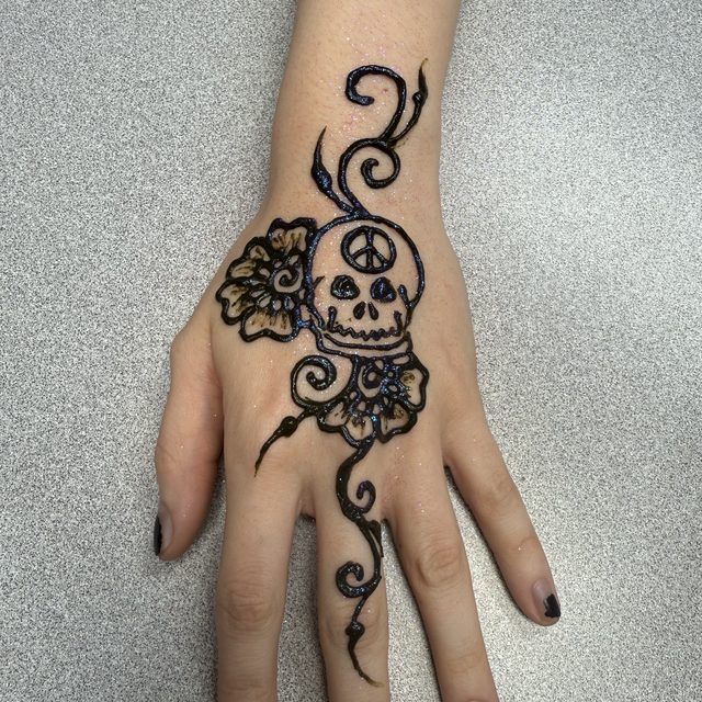 Skull and rose henna design on the hand