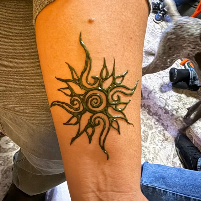 Tribal sun henna design on the forearm