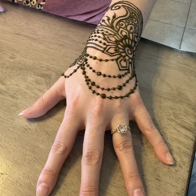Vine and bracelet-style henna design on the wrist
