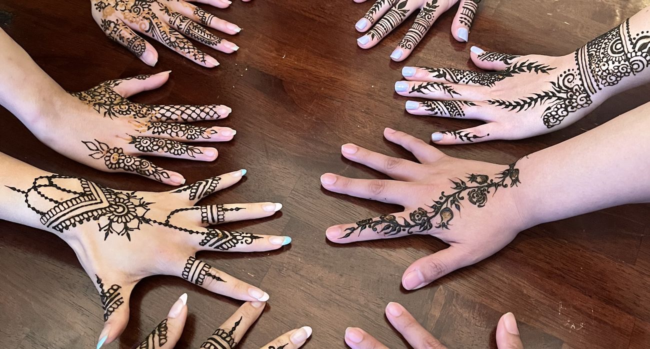 Group of henna-decorated hands arranged in a circle
